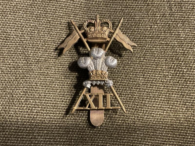 Gradia Militaria - Q/C 12th Lancers brass & white metal cap badge (1952–60)