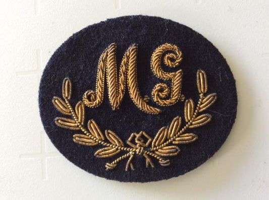 Gradia Militaria -  M.G ( Machine Gun) good bullion on dark blue wool trade badge