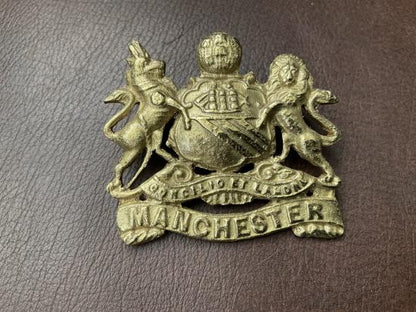 Gradia Militaria -  WW1 Egyptian made Manchester Regiment cap badge