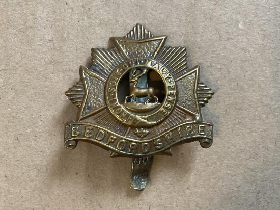 Gradia Militaria -  WW1 Bedfordshire Regiment brass economy cap badge