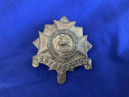 Gradia Militaria -  WW1 Bedfordshire Regiment economy brass cap badge.