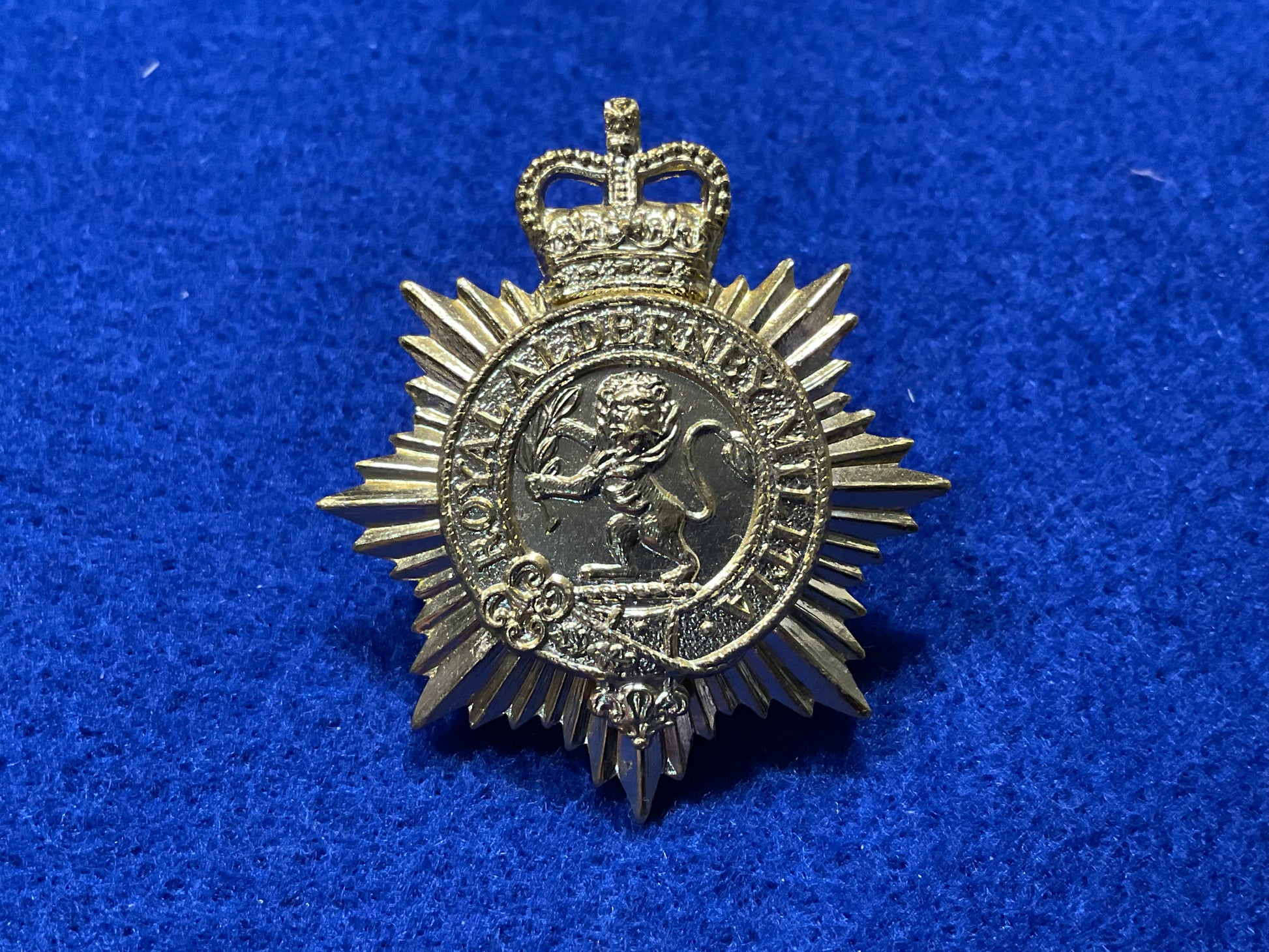 Anodised Royal Alderney Militia cap badge front