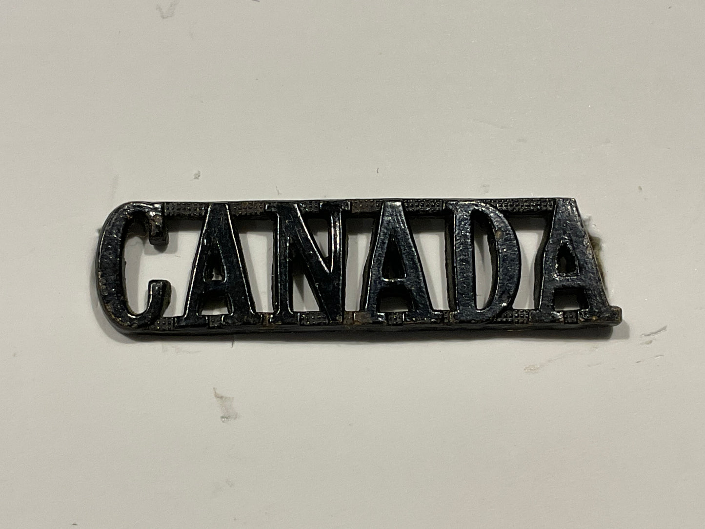 WW1 CEF small blackened brass ‘CANADA’ shoulder title