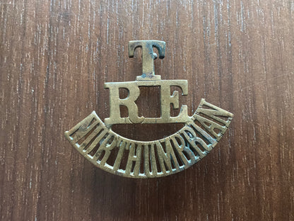 T/RE/NORTHUMBRIAN brass shoulder title.