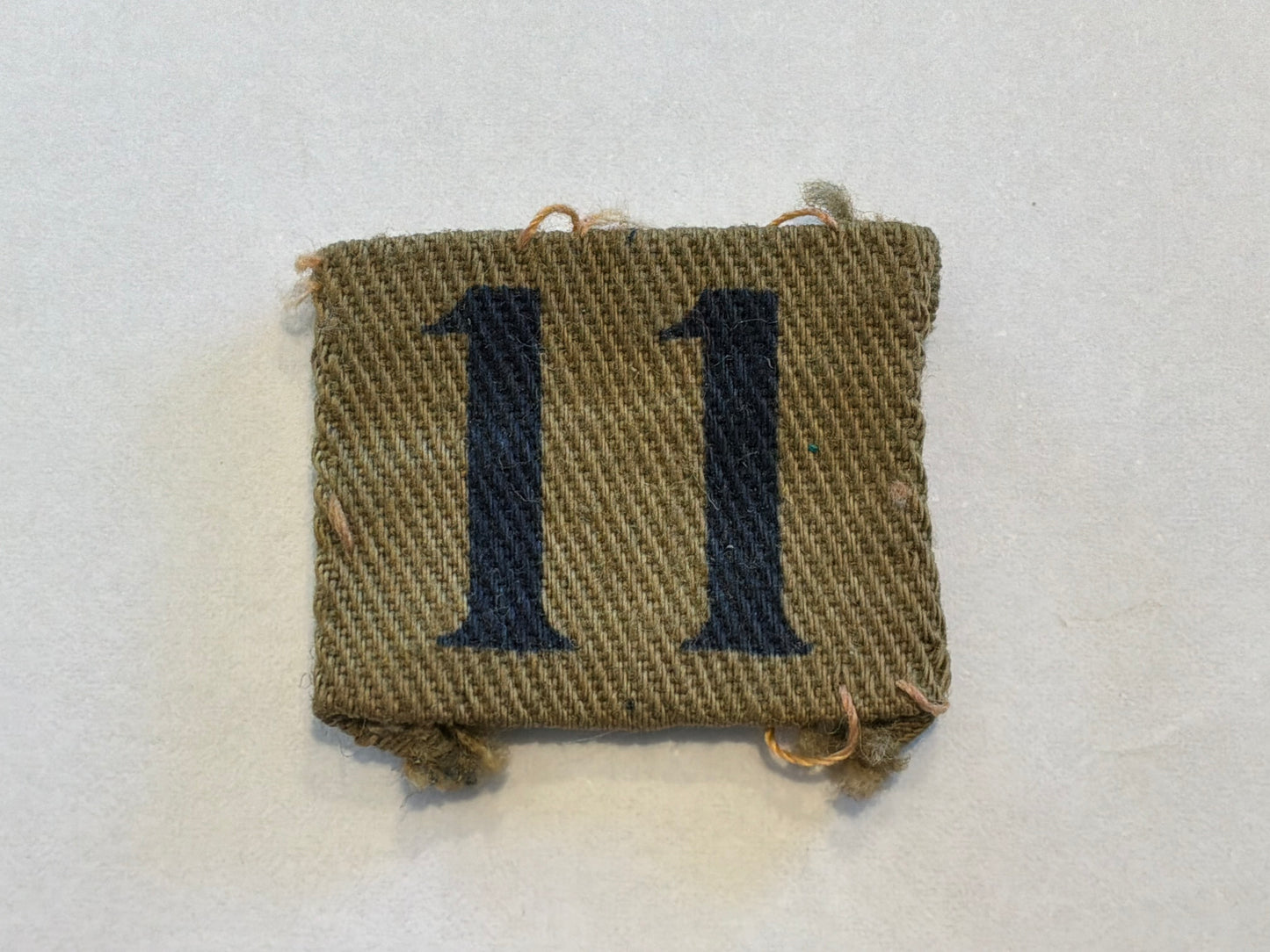 WW2 Printed number ‘11’ Home Guard designation badge.